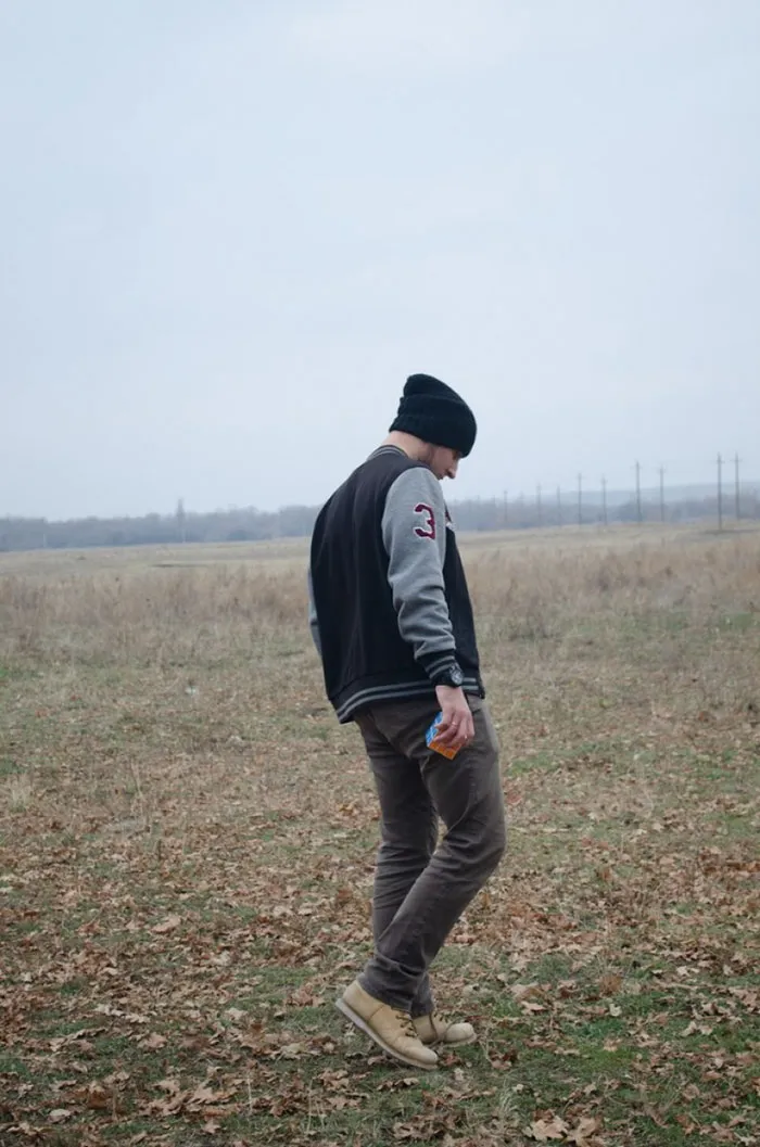 "Man in a field, wearing a beanie and jacket, showcasing the truth behind beautiful photos before Photoshop."