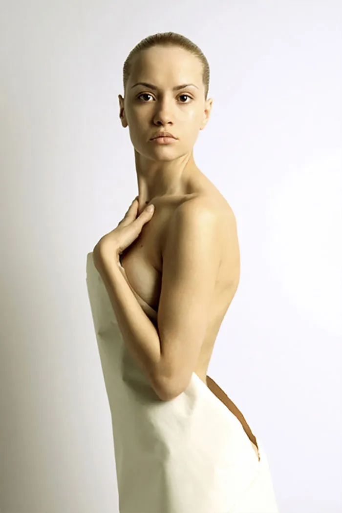 A woman posing confidently, illustrating before and after Photoshop effects in photography.