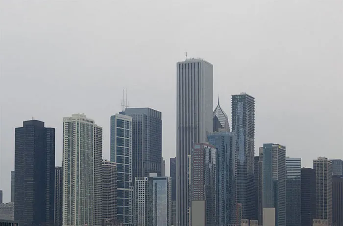 City skyline with skyscrapers under a cloudy sky, illustrating before and after Photoshop effects on urban scenes.