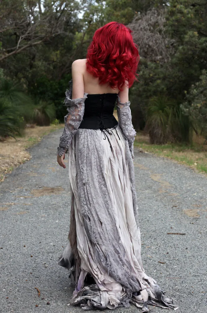 Red-haired woman in a flowing, vintage dress walking down a forest path, showcasing before and after Photoshop effects.