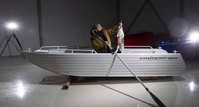 Man posing in a staged boat with dramatic lighting, illustrating Photoshop's impact on photos' truth perception.