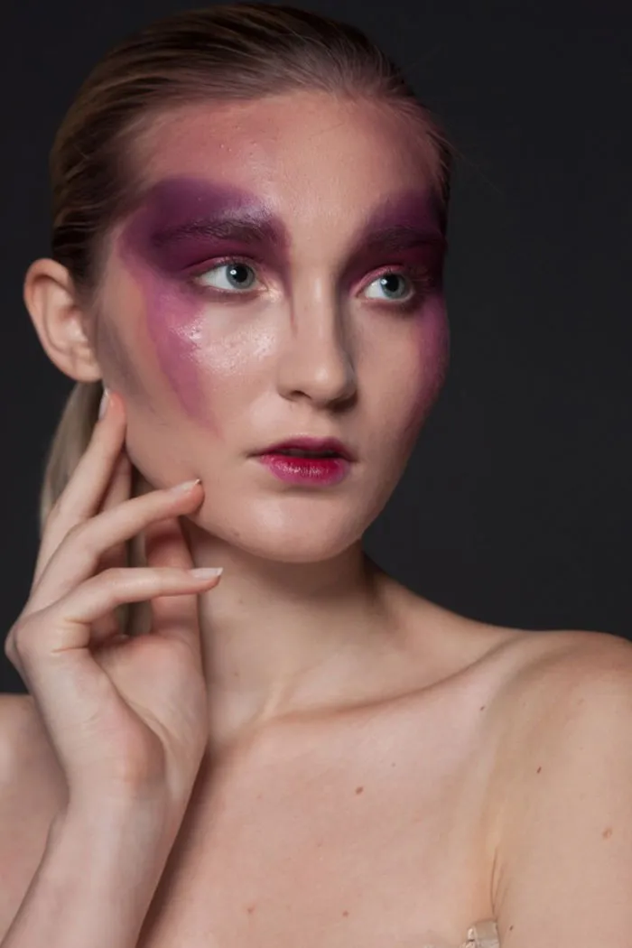 Close-up portrait of a woman with vibrant makeup, illustrating Photoshop's impact on beautiful photos.