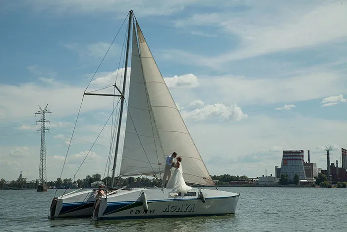 Sailboat on a lake with a couple embracing, showcasing the truth behind beautiful photos before Photoshop.