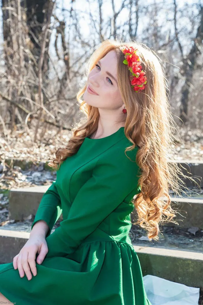 Woman in green dress with floral headband sitting outdoors, showcasing beauty and the power of Photoshop.