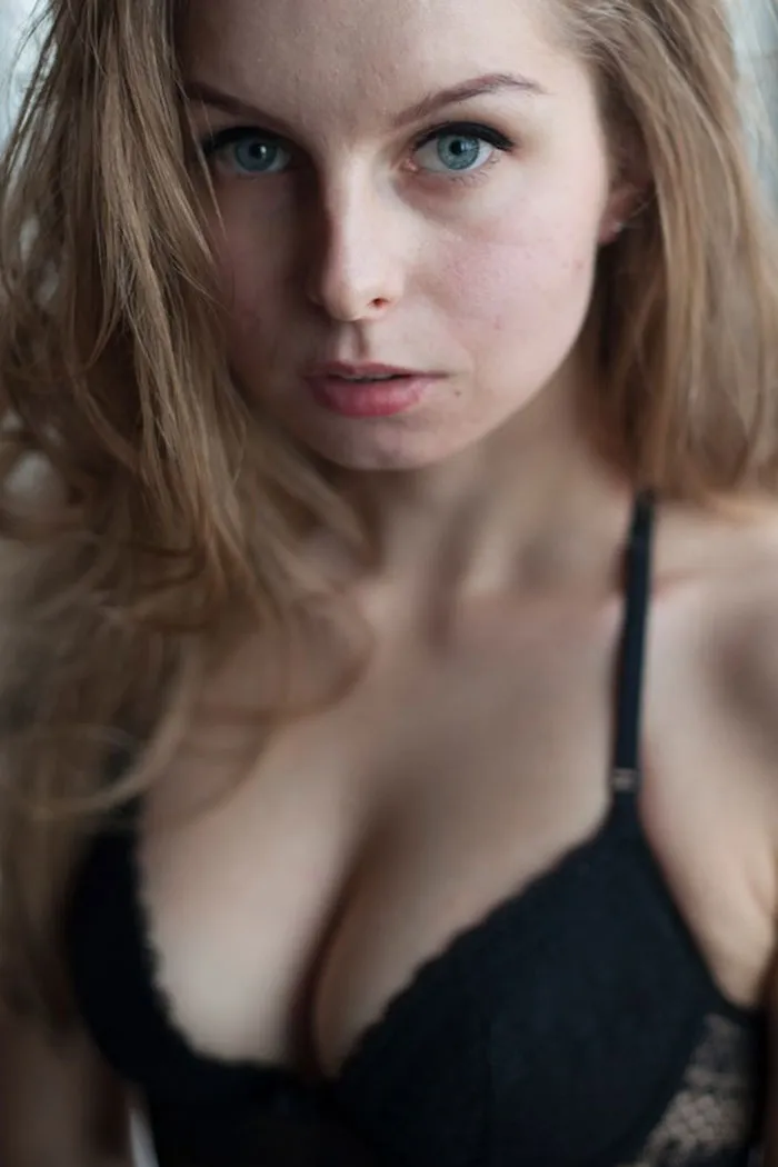 Woman posing in black lingerie, emphasizing natural beauty before Photoshop edits.