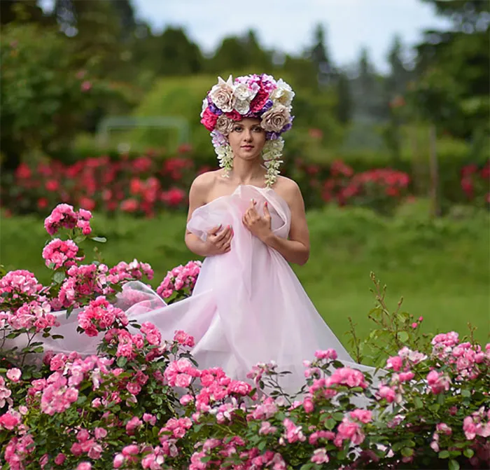 A woman in nature wearing a floral headdress and pink fabric, highlighting beauty transformation before Photoshop.