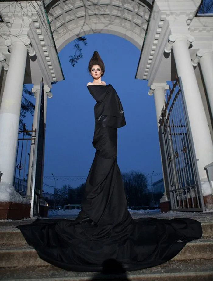 Fashion model in dramatic black gown, showcasing the truth behind beautiful photos with stunning architecture backdrop.