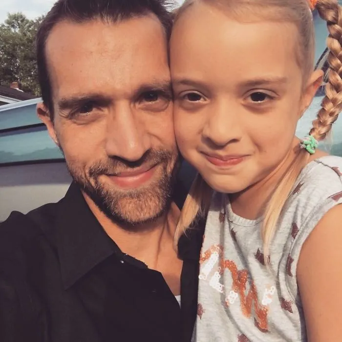 Man with beard and young girl smiling closely together, illustrating positive changes from before and after quitting drinking.