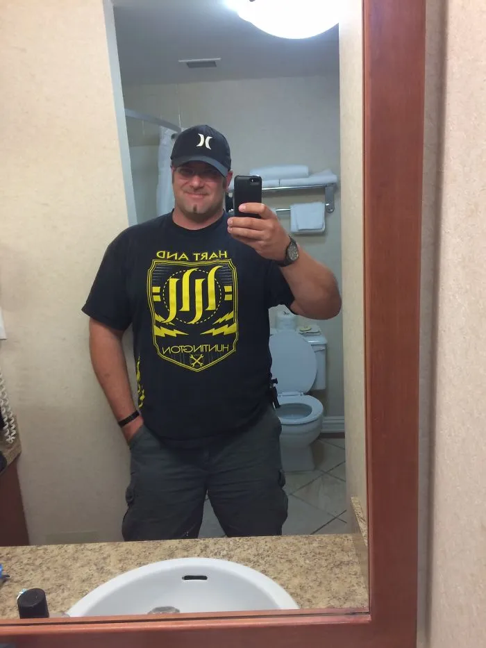 Man taking a bathroom mirror selfie, showing transformation in before-and-after pics when you stop drinking.