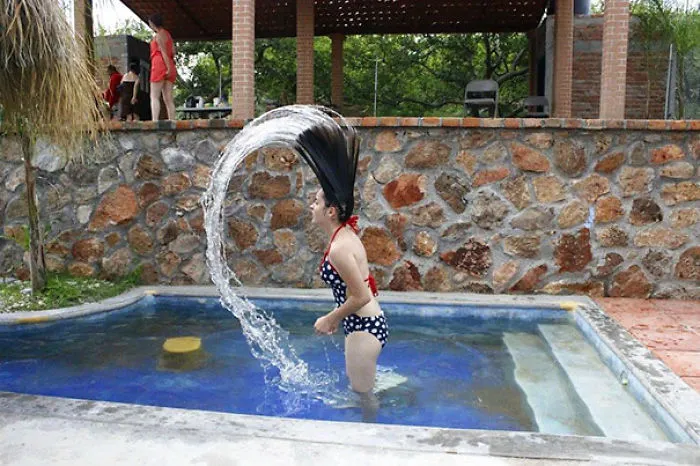 Person flipping hair in a pool, creating a water arc; an amusing "when you see it" moment.