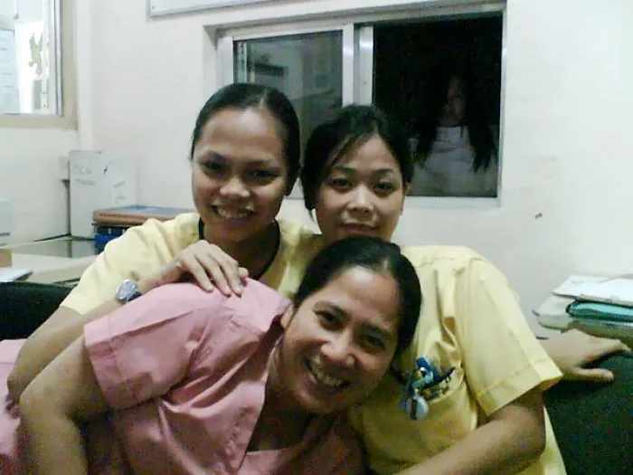 Three women smiling in a room with a spooky figure appearing in the window, creating a chilling "when you see it" moment.