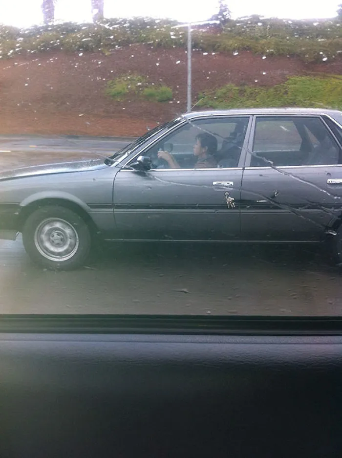 A car with keys dangling from the door, capturing a surprising moment on a rainy day.
