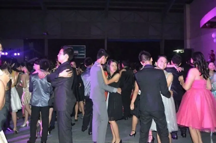 People dancing at a party, with an eerie figure that might freak you out when you see it.