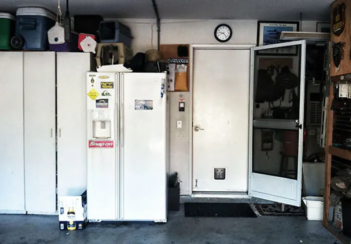 A seemingly normal garage with a fridge and open door, but a hidden detail that may freak you out when you see it.