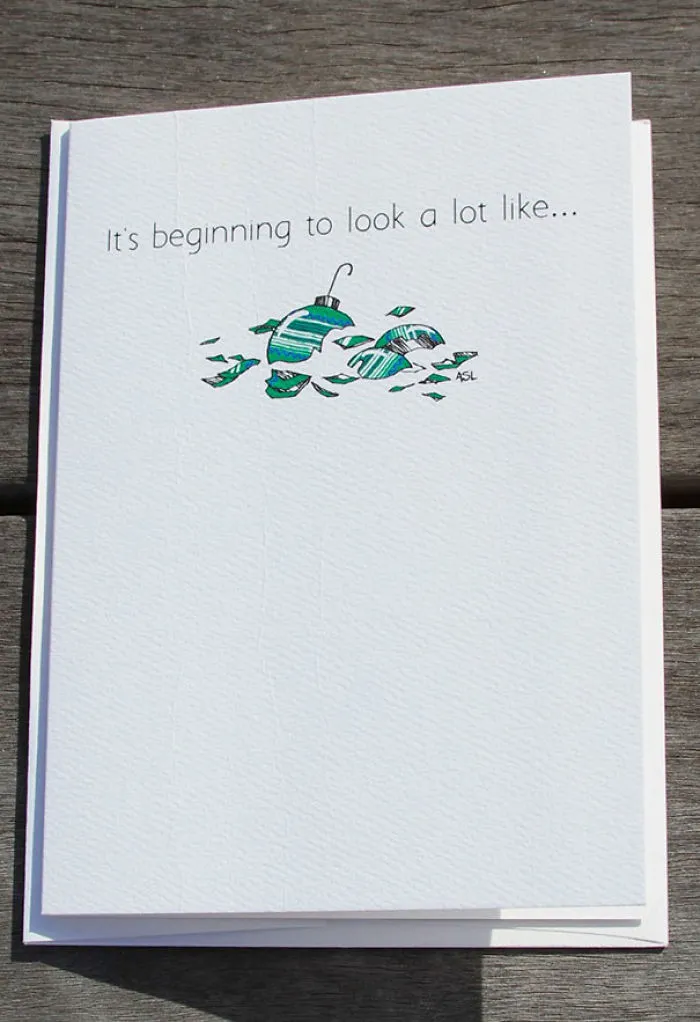 Rude Christmas card with broken ornament illustration and the text “It’s beginning to look a lot like...”.