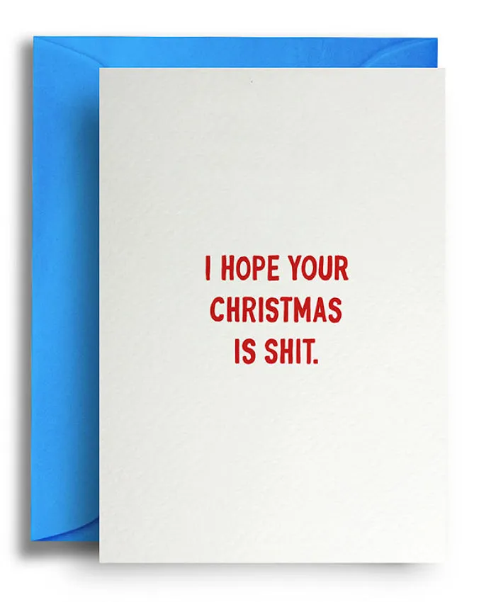 Rude Christmas card with red text reading "I hope your Christmas is shit" on a white card with blue envelope.