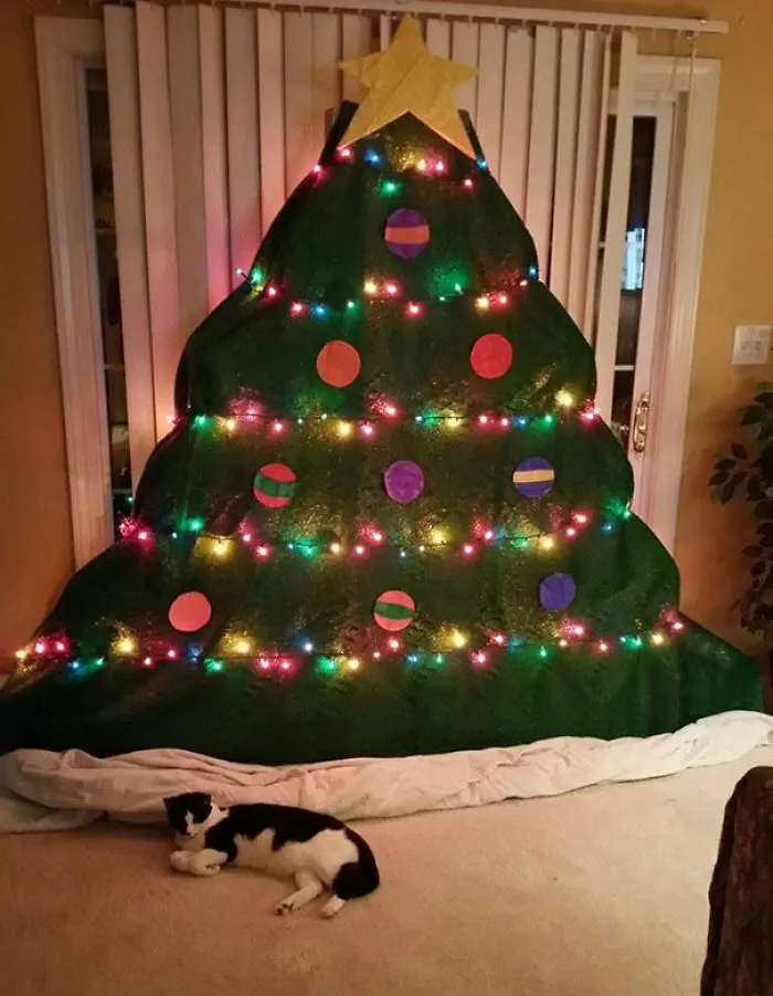 Flat decorative Christmas tree on wall protecting it from cats.