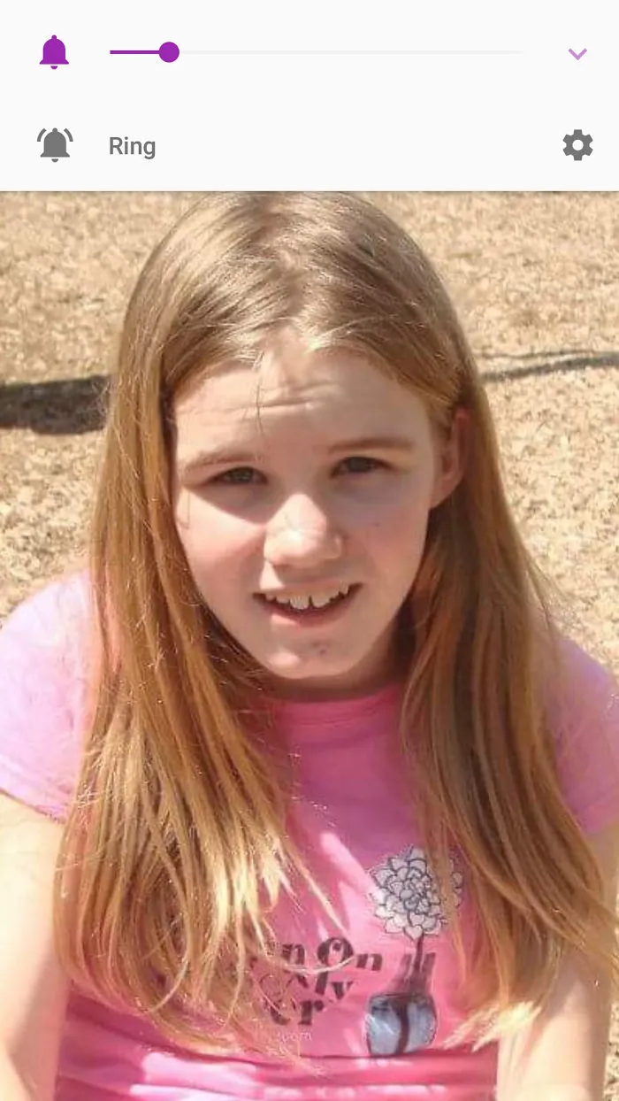 Child with uneven haircut, wearing a pink shirt outside, showing a regretful expression after cutting their own hair.