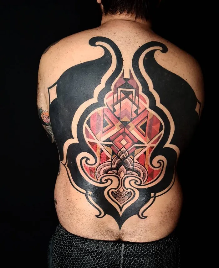 Back tattoo inspired by Amazonian tribal art, featuring bold geometric patterns by Brazilian artist.