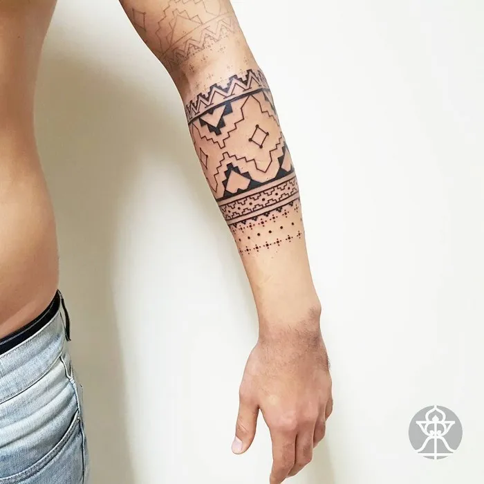 Brazilian tribal-inspired tattoo on a person's forearm by artist Brian Gomes, featuring intricate geometric patterns.