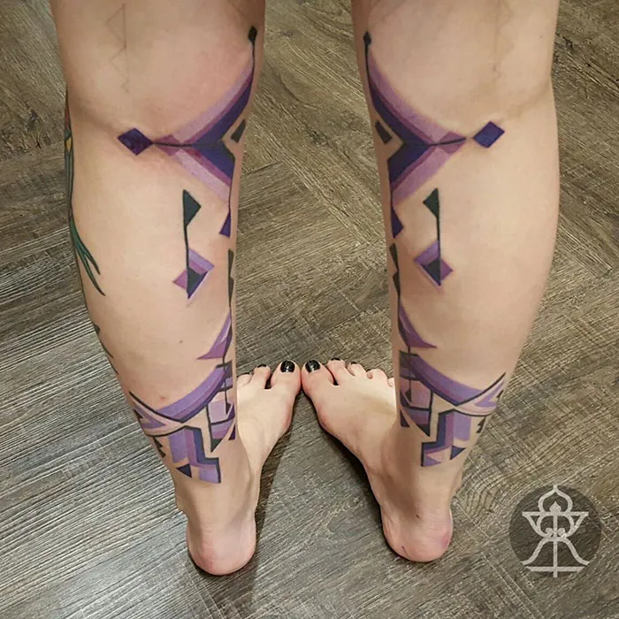 Amazonian tribal art-inspired leg tattoos by Brazilian artist Brian Gomes, featuring purple geometric designs.