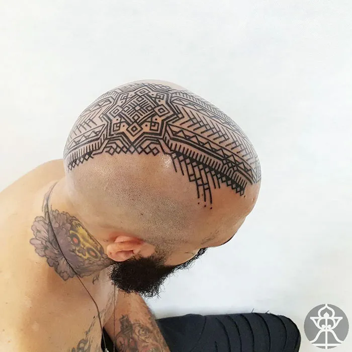 Man with intricate Amazonian tribal tattoo by Brazilian artist Brian Gomes on his head.