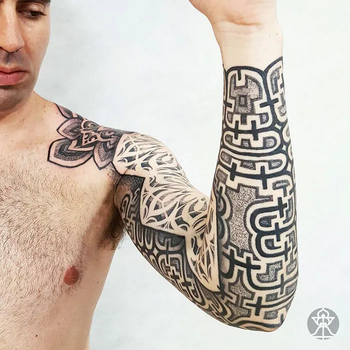 Close-up of a man's arm featuring intricate Amazonian tribal art tattoo design by Brazilian artist.