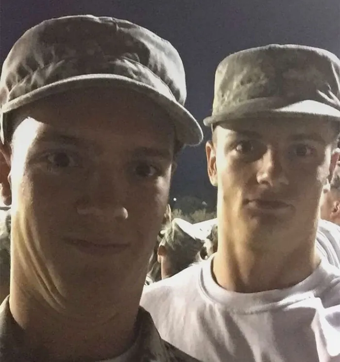 Two men in military uniforms standing closely, appearing as real-life doppelgangers.