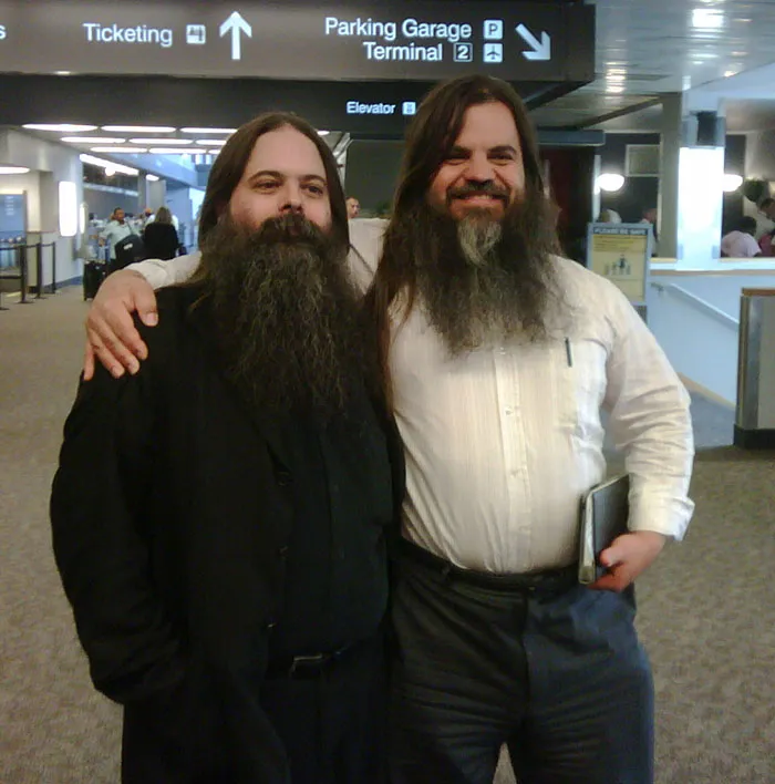 Two men with long beards and dark hair meet their real-life doppelgangers at an airport.