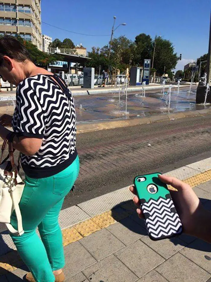 Person in zigzag top on street, matching phone case pattern, evoking "Who Wore It Better?" humor.