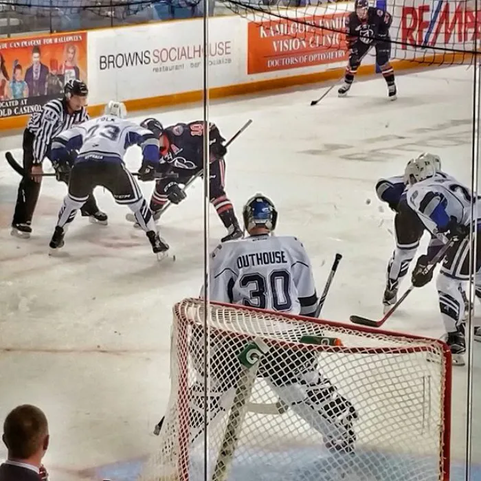 Hockey game action with a goalie named Outhouse wearing jersey number 30, capturing a humorous sports moment.