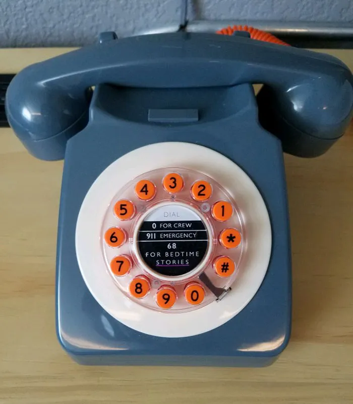 a blue retro phone with orange buttons