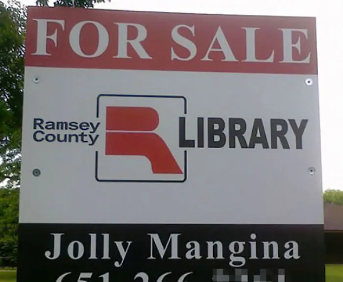 "For sale sign outside Ramsey County Library with a funny name below."