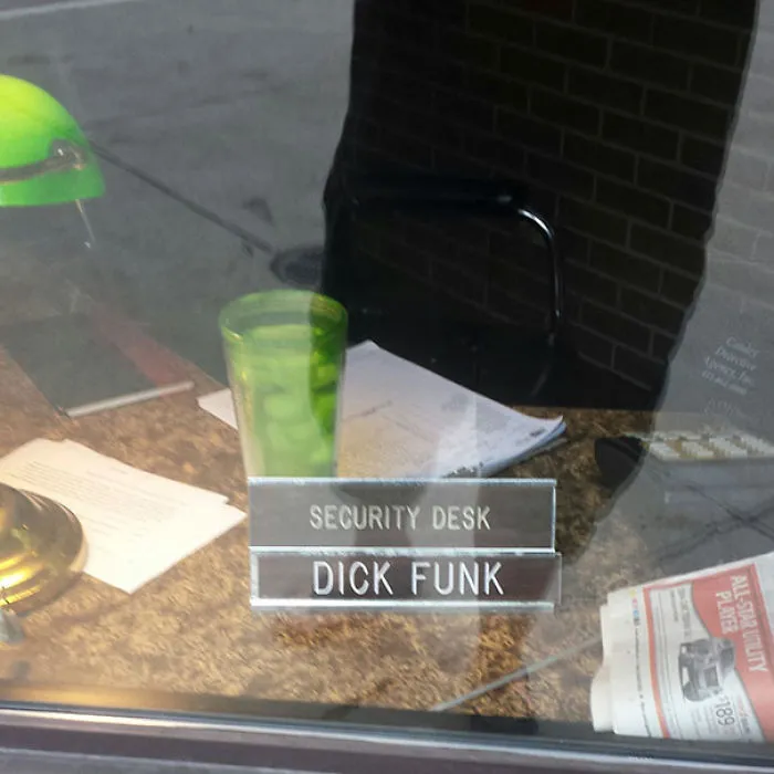 Security desk with a nameplate reading "Dick Funk," featuring funny names in an office setting.