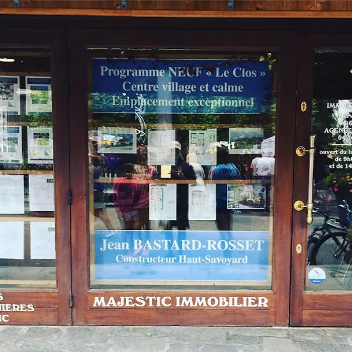 Storefront window displaying the funny name "Jean Bastard-Rosset" at a real estate office.