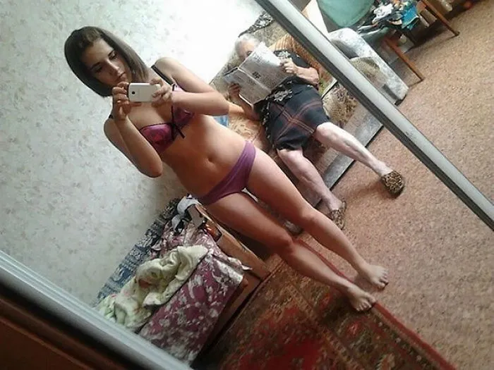 Woman taking mirror selfie with grandma in the reflection 