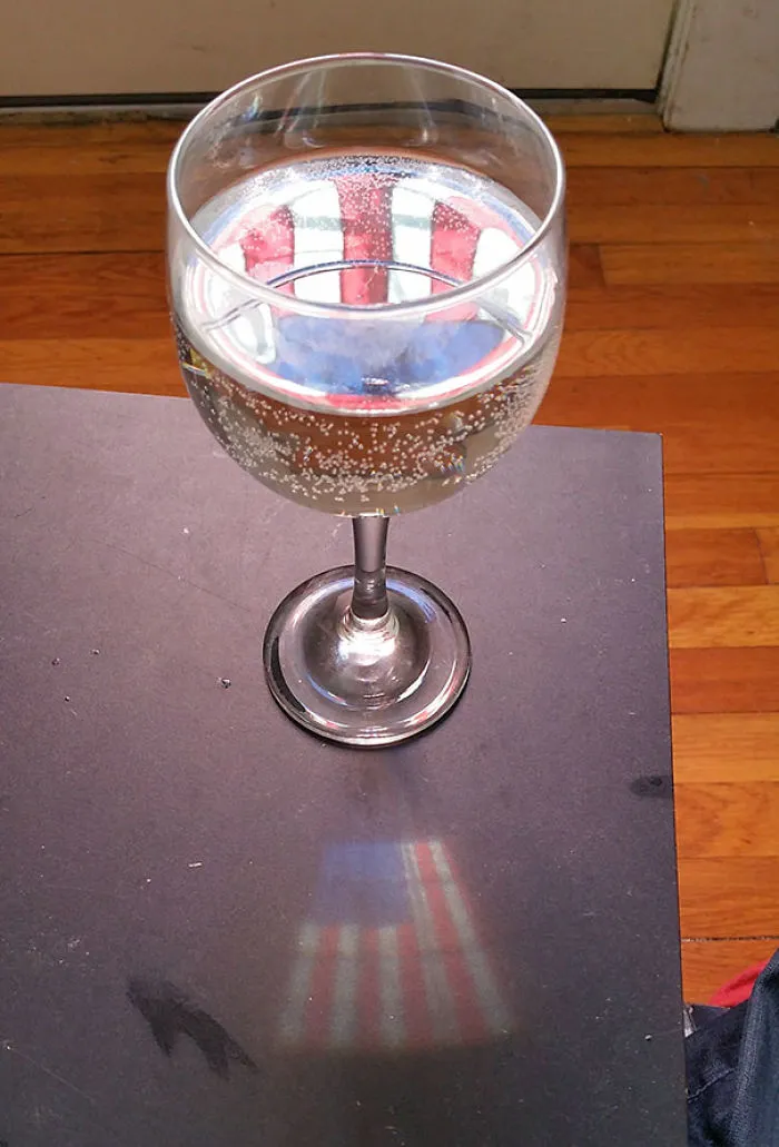 The Wine Glass Projected The Flag In The Window On To The Table