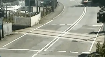 A driver narrowly escapes a train crossing, illustrating risks impacting why women live longer than men.