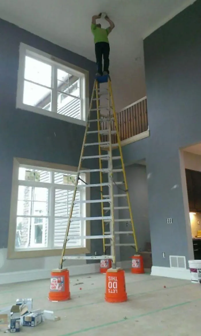 Man on a precarious ladder setup, highlighting risky behavior and safety concerns related to why women live longer than men.