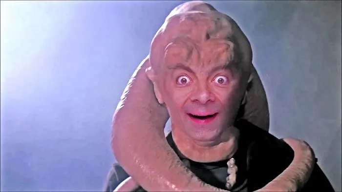 Mr. Bean photoshopped onto a sci-fi creature with an exaggerated surprised expression in a dark background.