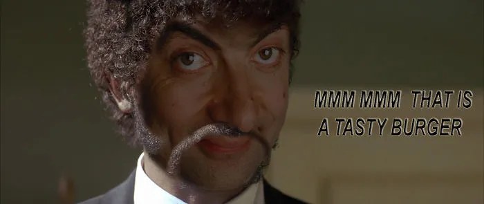 Close-up of Mr. Bean Photoshopped with exaggerated facial hair saying mmm mmm that is a tasty burger.