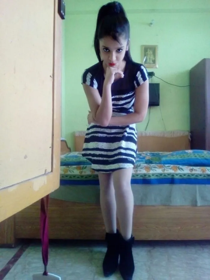 Young woman posing in a striped dress and black boots indoors, featured in content about people photoshopping Mr Bean humorously.