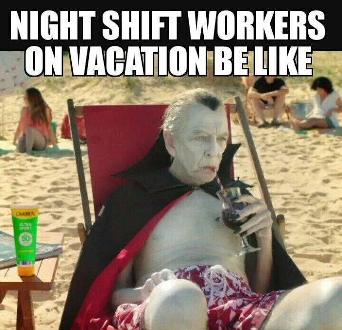 Funny work meme of a vampire on vacation, sipping a drink on the beach in swim trunks.