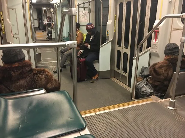 Two womans sitting in the bus and wearing same clothes