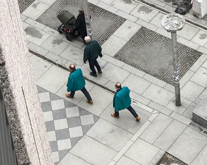 Two man walking and wearing same blue clothes