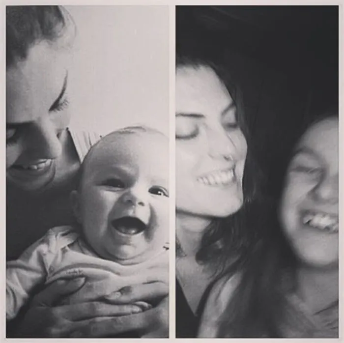 Black and white photo of mother and smiling baby recreated by siblings