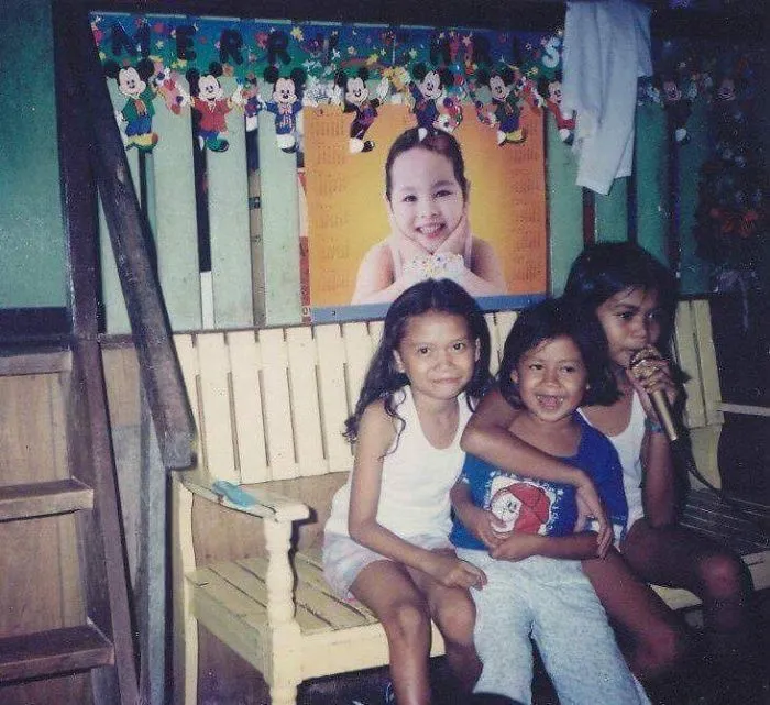 Children posing on bench near birthday decorations in cute siblings photo