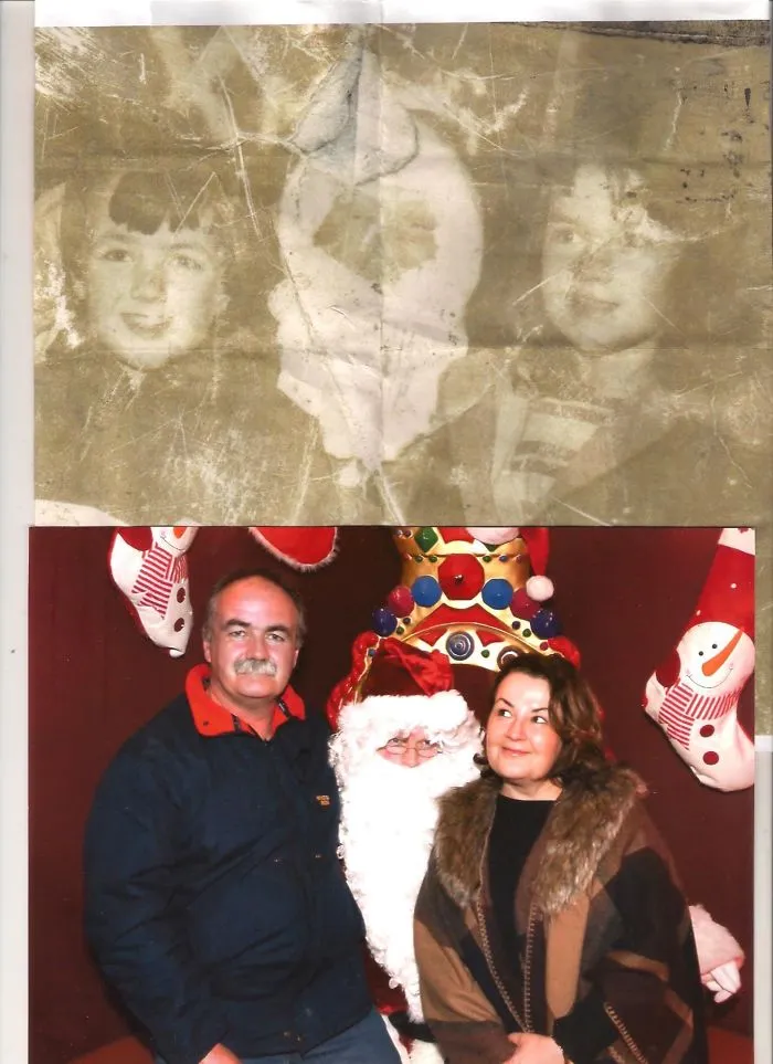 Older couple posing with Santa in recreated family holiday photo
