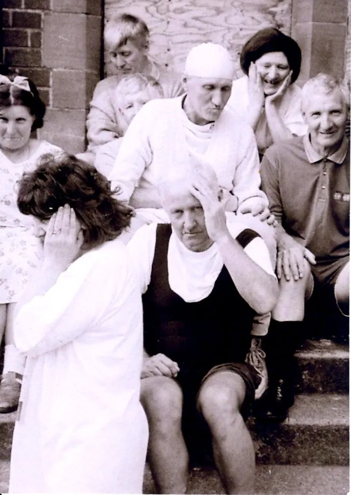 Black and white family photo showing humorous facial expressions on steps