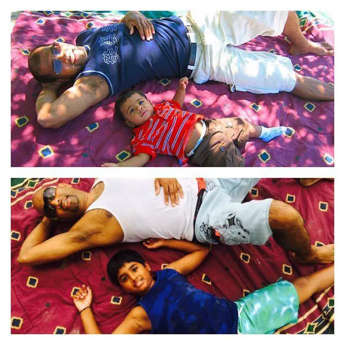 Father and son lying on a picnic blanket in matching poses